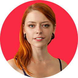Redheaded woman in a black tank top smiles into the camera.